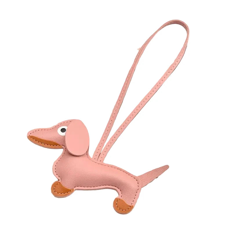 Pink dachshund-shaped keychain on a white background