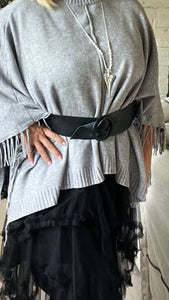 This black leather belt features a circular fixing, perfect for styling over a jumper 